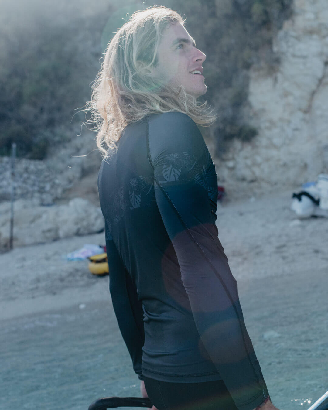 Man on Beach Wearing Sustainable Custom Rash Guard